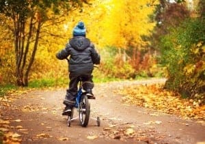 Boy riding bicycle in the fall.