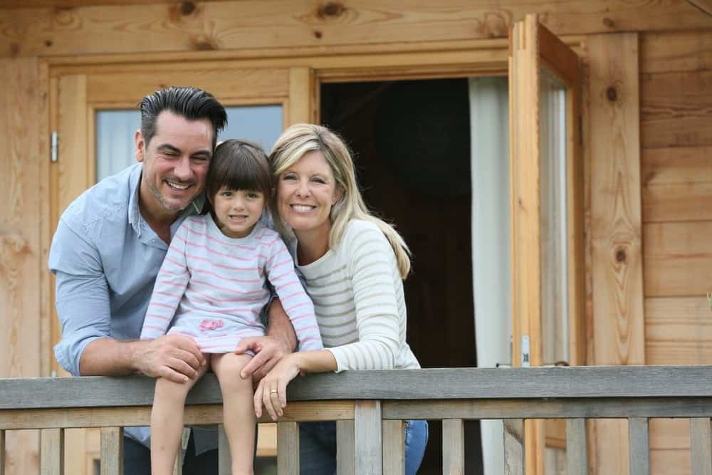 Happy family on the porch of one of the Smoky Mountain log cabins in Tennessee.