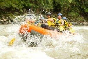 A group of people white water rafting on a river.