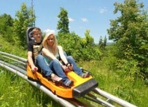 couple riding alpine coaster in the mountains