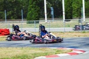 Two men racing on a go kart track.